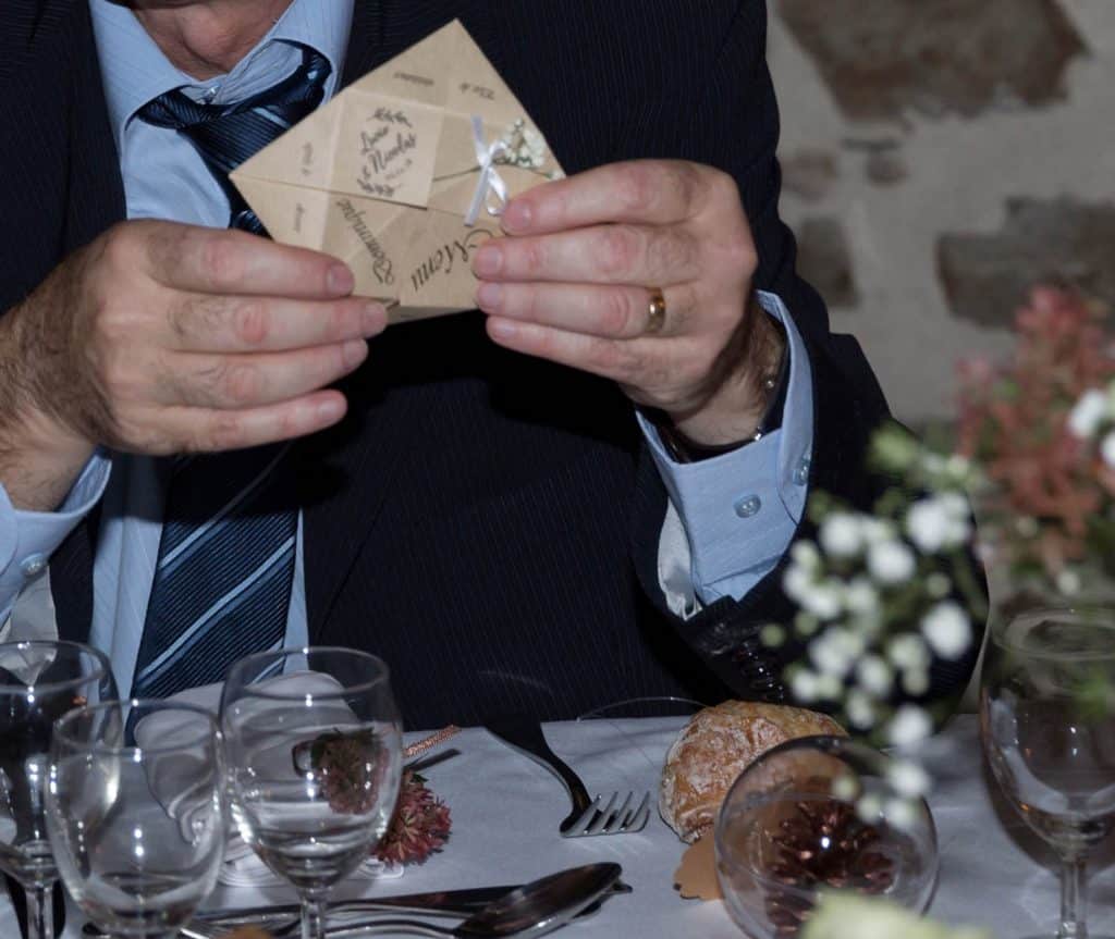 Invité découvrant le menu de mariage en jouant avec la cocotte